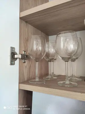 four empty wine glasses sitting on a shelf at Senamiesčio apartamentai in Druskininkai