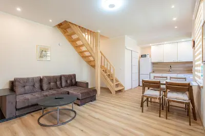 a living room with a couch and a table at Senamiesčio apartamentai in Druskininkai