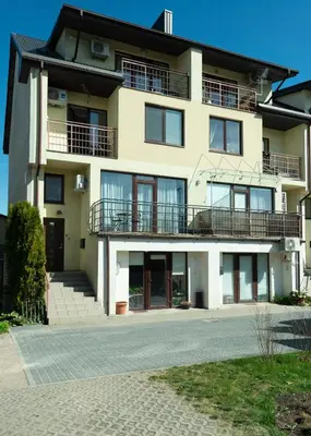 an apartment building with a balcony and a driveway at Poilsis klonyje in Druskininkai