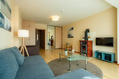 a living room with a blue couch and a table at Poilsis klonyje in Druskininkai
