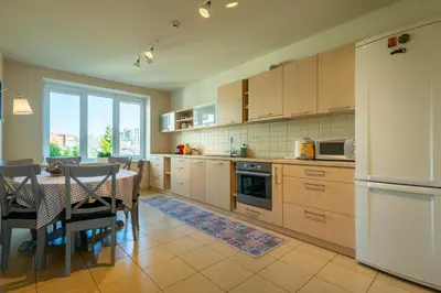 a kitchen with a table and a dining room at Poilsis klonyje in Druskininkai