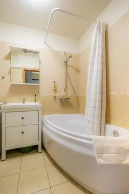 a bathroom with a white tub and a sink at Poilsis klonyje in Druskininkai