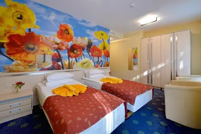 two beds in a room with flowers painted on the wall at Mineral SPA Draugystė in Druskininkai