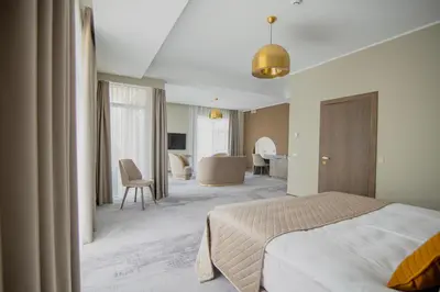 a bedroom with a bed and a living room at Mineral SPA Draugystė in Druskininkai