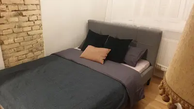 a bedroom with a large gray bed with pillows at kauno street home in Vilnius