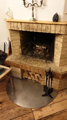 a stone fireplace in a living room with a table at kauno street home in Vilnius