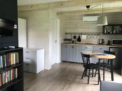 a kitchen with a table and chairs in a room at Atostogų namelis Laukys in Druskininkai