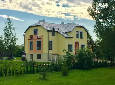 a large yellow house with a metal roof at Wonderful 8 Bedroom Home near Vilnius in Didžioji Reišė