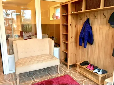 a white chair in a room with some shoes at Wonderful 8 Bedroom Home near Vilnius in Didžioji Reišė