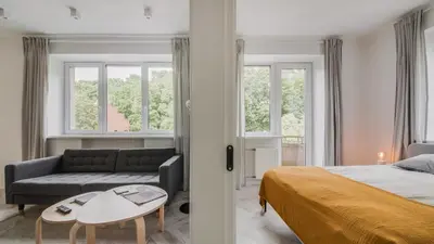 a bedroom with a bed and a couch and a table at Central Apartment in Architectural Street in Kaunas