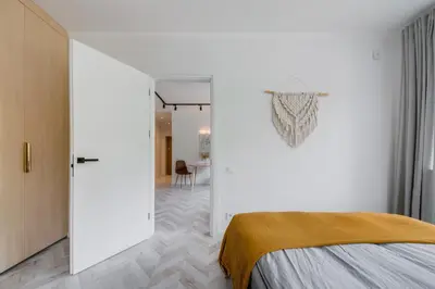 a bedroom with a bed and a white wall at Central Apartment in Architectural Street in Kaunas