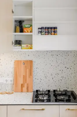 a kitchen with a stove top and white cabinets at Central Apartment in Architectural Street in Kaunas