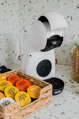 a coffee maker next to a basket of oranges at Central Apartment in Architectural Street in Kaunas