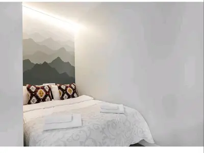 a bedroom with a bed with a painting on the wall at HaPPy Inn VIP, Self Check-In-24x7, A-C, Parking-in-the-underground-Garage in Vilnius