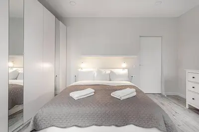 a bedroom with a bed with two towels on it at HaPPy Inn VIP, Self Check-In-24x7, A-C, Parking-in-the-underground-Garage in Vilnius