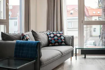 a living room with a couch and a large window at HaPPy Inn VIP, Self Check-In-24x7, A-C, Parking-in-the-underground-Garage in Vilnius
