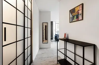 a hallway with a black book shelf and a painting on the wall at HaPPy Inn VIP, Self Check-In-24x7, A-C, Parking-in-the-underground-Garage in Vilnius