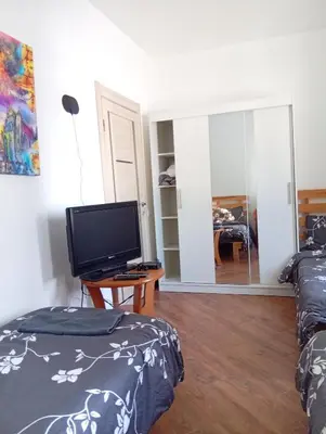 a living room with two beds and a television at Svečių namai prie Širvintų in Akmeniai