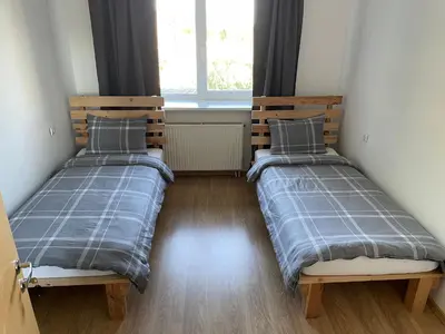 two twin beds in a room with a window at Svečių namai prie Širvintų in Akmeniai