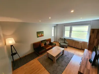 a living room with a couch and a table at Apartamentai ŠERMUKŠNIS in Druskininkai