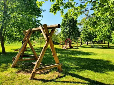 a wooden structure in a park with a playground at Apartamentai ŠERMUKŠNIS in Druskininkai
