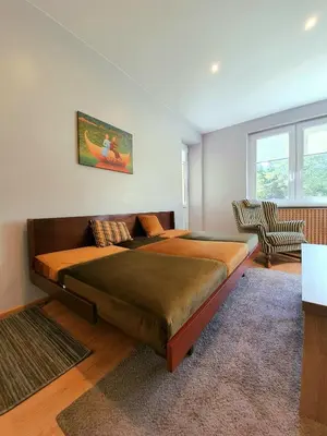 a bedroom with a large bed in a room at Apartamentai ŠERMUKŠNIS in Druskininkai