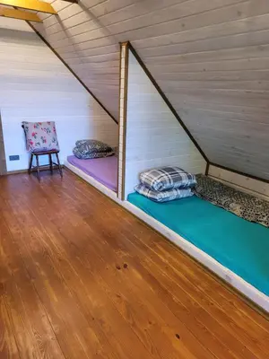 a room with two bunk beds and a chair at Nuomojama sodyba Rokiškio rajonas , Aukštakalnių kaimas ,Ežero gatvė 2 in Kuosiai