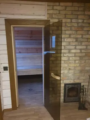 a room with a door leading to a room with a fireplace at Nuomojama sodyba Rokiškio rajonas , Aukštakalnių kaimas ,Ežero gatvė 2 in Kuosiai