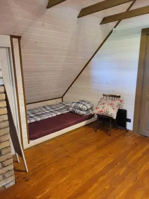 a room with a bed and a bench in a attic at Nuomojama sodyba Rokiškio rajonas , Aukštakalnių kaimas ,Ežero gatvė 2 in Kuosiai