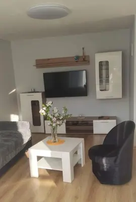 a living room with a couch and a table with a vase of flowers at Butas miesto centre/ Apartment in the city center in Šiauliai