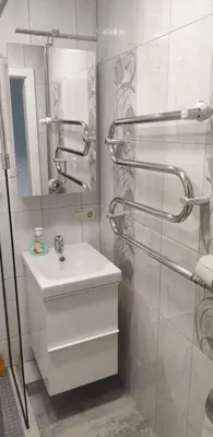a white bathroom with a sink and a mirror at Butas miesto centre/ Apartment in the city center in Šiauliai