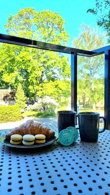 a table with a plate of food and two pastries at Park Premium Apartments in Birštonas