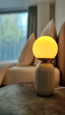 a yellow lamp sitting on a table in front of a couch at Park Premium Apartments in Birštonas
