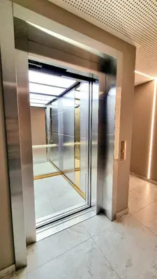 an elevator lobby with a glass door in a building at Park Premium Apartments in Birštonas