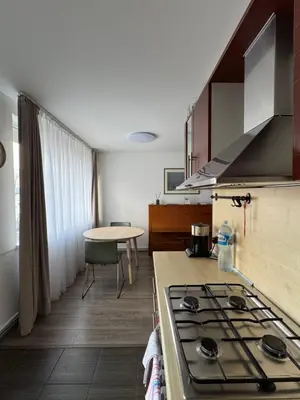 a kitchen with a stove top oven next to a table at APARTMENTS IN THE CITY CENTER BIRŽAI Vytauto g22 in Biržai