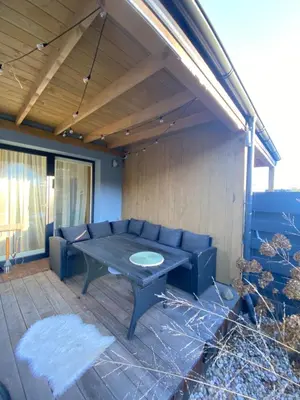 a patio with a blue couch and a table at Atostogų namas Twins in Druskininkai