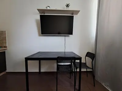 a black table with chairs and a flat screen tv at Cozy place in Žirmūnai 2 in Vilnius