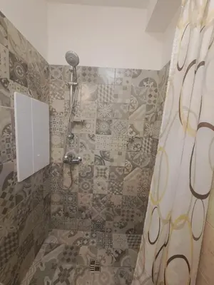 a shower with a shower curtain in a bathroom at Cozy place in Žirmūnai 2 in Vilnius