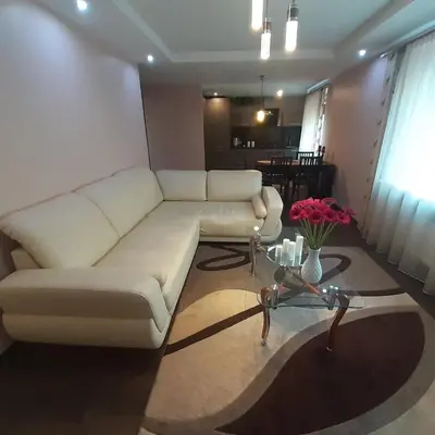 a living room with a white couch and a table at Jaukus butas Druskininkuose in Druskininkai