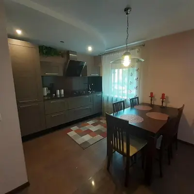 a kitchen and dining room with a table and chairs at Jaukus butas Druskininkuose in Druskininkai