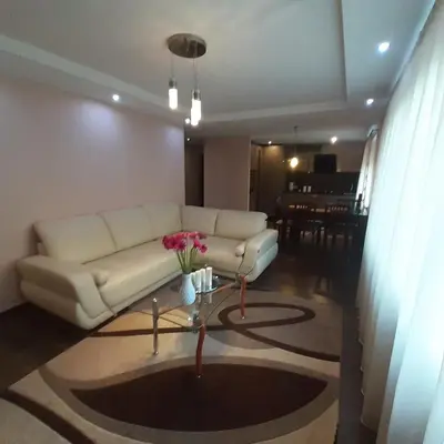 a living room with a white couch and a table at Jaukus butas Druskininkuose in Druskininkai