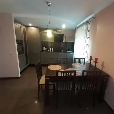 a kitchen and dining room with a table and chairs at Jaukus butas Druskininkuose in Druskininkai
