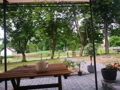a wooden table with a coffee cup on a patio at VEPA in Vepriai