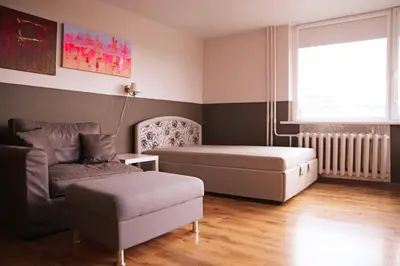 a bedroom with a bed and a couch and a window at Apartment for a short rent in KaunasButas trumpalaikei nuomai Kaune in Kaunas