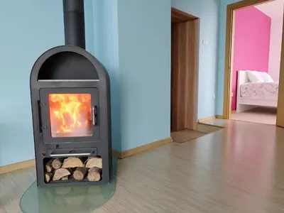 a fireplace with logs inside of a room at Spacious & Cozy Apartment with Forest View in Zapyškis