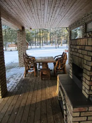 a patio with a table and chairs and a fireplace at Vanago Lizdas in Druskininkai