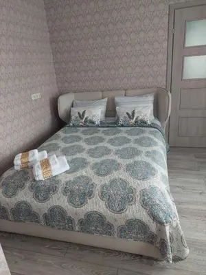 a bed with a comforter and pillows in a bedroom at Lapių Ola in Utena