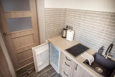 a small kitchen with a sink and a door at Lapių Ola in Utena