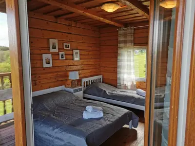 a bedroom with two beds in a log cabin at Sodyba 