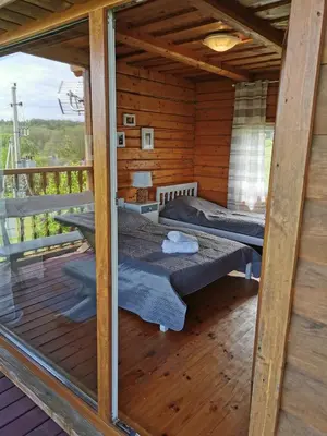 a room with two beds in a wooden house at Sodyba 